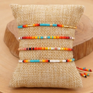 Set di quattro braccialetti bohémien in perline Miyuki con motivi geometrici su cuscino