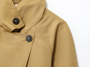 Detail of khaki twill fabric texture with dark brown buttons and precision stitching
