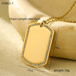 Detailed view of a gold plated dog tag pendant with sparkling rhinestones and size labels