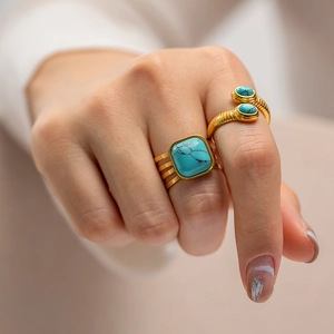 18K gold plated snake-shaped wrap ring and layered square turquoise ring set on finger