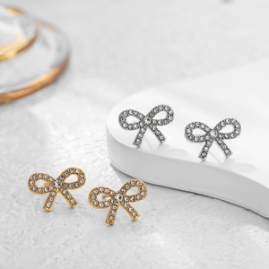 Elegant 18K gold and silver bow stud earrings with sparkling white cubic zirconia stones