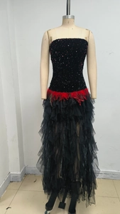 Detail of black sequined corset dress with contrasting red feather waist decoration