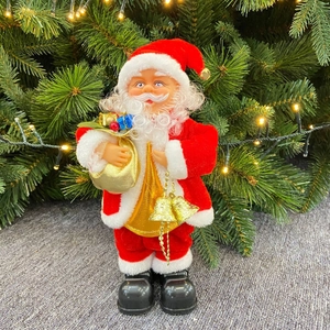 Detail of musical Santa Claus figure in red velvet suit holding golden gift bag and bell