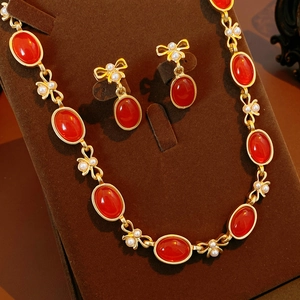 Detailansicht Vintage Gold-Schmuckset mit roten Edelsteinen, Perlen und Schleifen