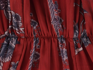 Detail of floral chiffon fabric with waist stitching and deep red patterned texture