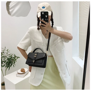 Chic black crossbody bag styled with a tweed jacket and casual outfit in a bright room