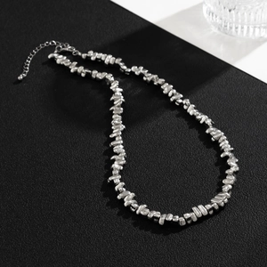 Mens irregular silver CCB bead necklace with lobster clasp on textured surface