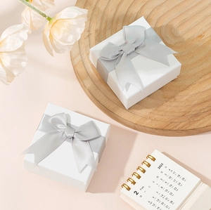 Elegant white jewelry gift boxes with grey ribbon bows for rings and necklaces
