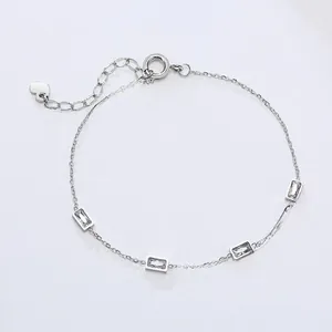 Detail of silver chain bracelet featuring four rectangular zircons and a small heart charm