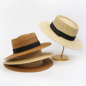Detail of woven straw boater hats with black ribbons in tan and beige colors