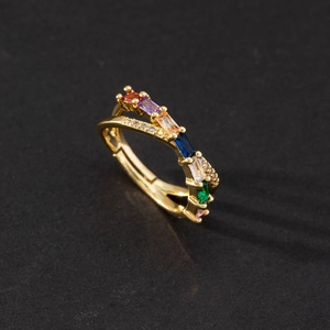 Macro detail of gold crossover ring featuring multi-color rectangular zircon stones