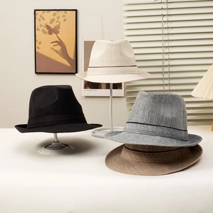 Classic straw jazz hats in black and beige colors with minimalist striped ribbon decoration