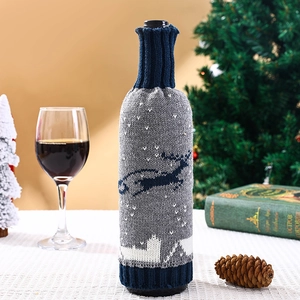 Détail d'un cache-bouteille de vin tricoté avec motifs de renne gris et de flocons de neige