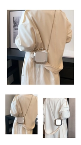 Octagonal silver acrylic clutch bag with chain strap shown on beige trench coat