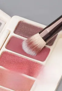 Close-up of fluffy eyeshadow brush capturing powder texture with soft synthetic bristles