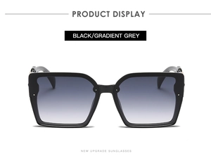 Detail of square black sunglasses featuring gradient grey lenses and polished frames