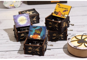 Macro view of hand-cranked wooden Halloween music box featuring spooky party engravings