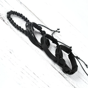 Close-up of a four-piece black leather bracelet set with an infinity symbol and wood beads