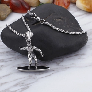 Macro detail of silver surfing surfer pendant with twist chain on natural stone