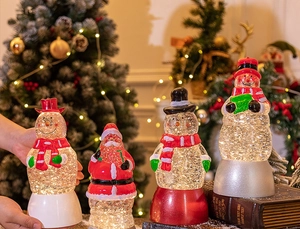 Detailansicht von vier festlichen Weihnachts-Schneekugeln mit Weihnachtsmann- und Schneemann