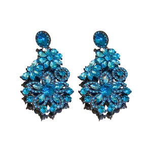 Vintage style floral drop earrings featuring blue crystals and silver needles on white background