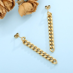 Detail of golden Cuban chain drop earrings with butterfly backing on light blue surface