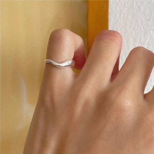 Close-up of minimalist 925 sterling silver wavy ring with high-polished mirror finish