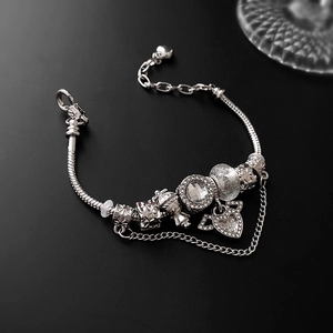 Silver snake chain charm bracelet featuring heart wing pendants and sparkling crystals