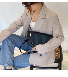 Detail of black PU leather crescent waist bag featuring adjustable strap and smooth zipper