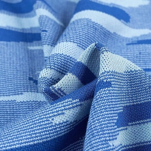 Vue détaillée de la texture du tissu tricoté bleu avec motifs de vagues abstraites