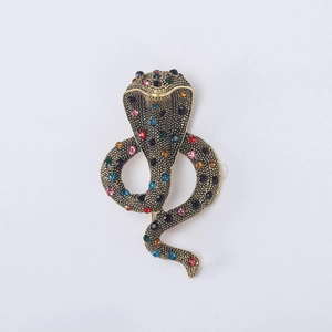 Macro view of cobra brooch with multicolor rhinestones and golden metal textures