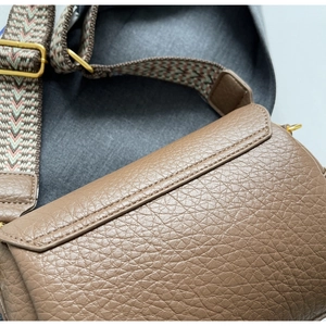 Détail du cuir marron à motif litchi avec bandoulière tissée à motifs géométriques