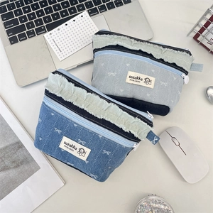Detailansicht von zwei Denim-Patchwork-Kosmetiktaschen mit Reißverschlüssen auf Tisch
