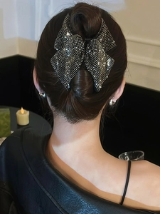 Elegant black bow hair claw clip with sparkling rhinestones worn on hair back