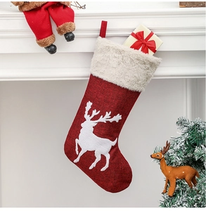 Classic red Christmas stocking with plush cuff hanging on a festive decorated fireplace