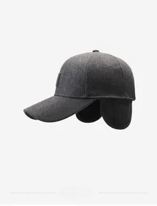 Detail view of dark grey wool baseball cap with ear flaps and text embroidery
