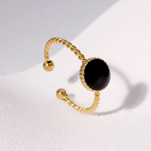 Macro shot of 18K gold plated twisted rope ring with a black circular onyx-style inlay