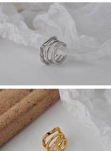 Macro shot of silver and gold layered ear cuffs featuring micro-pave zircons on a white backdrop