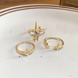 Detailed shot of three gold star-themed rings with blue zircon and sparkling accents