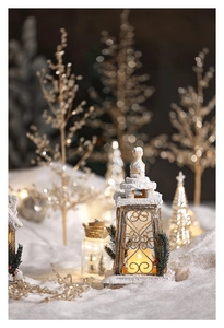 Close-up of wooden Christmas house lantern with warm LED light and snow details