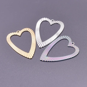 Detail of heart-shaped pendants in gold, silver and rainbow colors for jewelry DIY