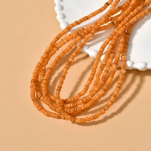 Macro detail of 4mm orange freshwater shell disc beads for DIY jewelry making