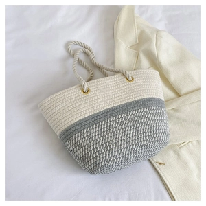 Detailed weave of beige and grey cotton rope tote bag with golden metal ring hardware