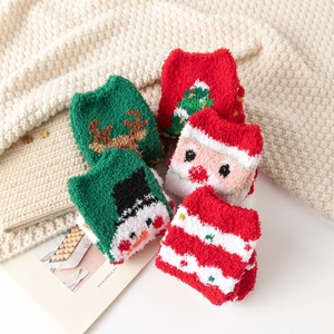 Détail de cinq paires de chaussettes de Noël en polaire corail sur couverture tricotée