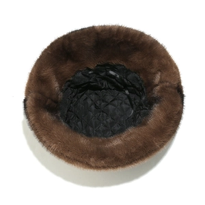 Detail of brown faux fur bucket hat with black quilted lining for winter warmth