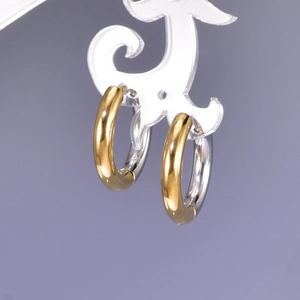Detail of two-tone gold and silver polished stainless steel hoop earrings on a stand