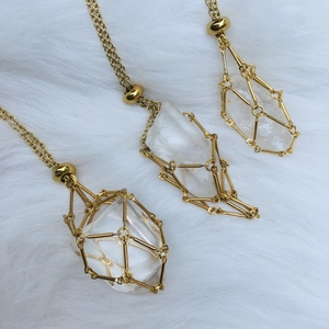 Detail of three natural quartz crystals wrapped in golden metal wire mesh on white fur