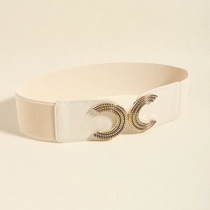 Macro shot of cream elastic corset belt featuring a textured gold double C buckle detail