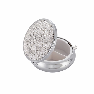 Macro view of silver rhinestone pill box showing the interior two-compartment storage
