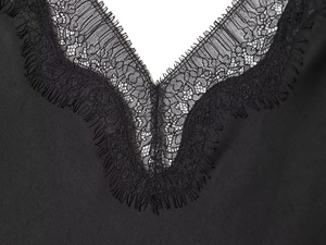Détail du col en V élégant avec dentelle de cils noire et tissu en satin lisse soyeux
